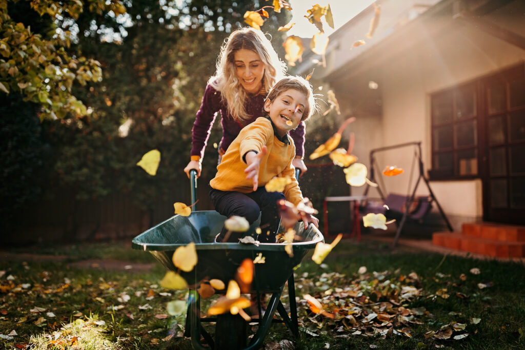 mom and son playing in the backyard in fall