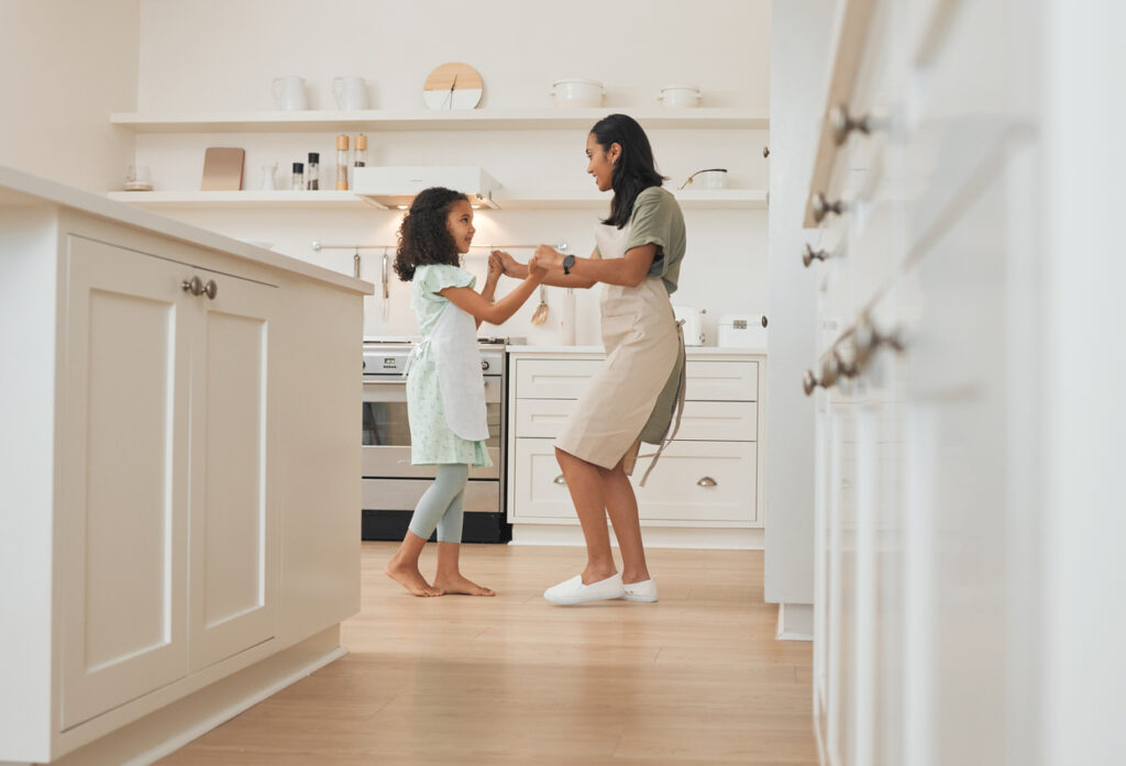 mom and daughter dancing in kitchen