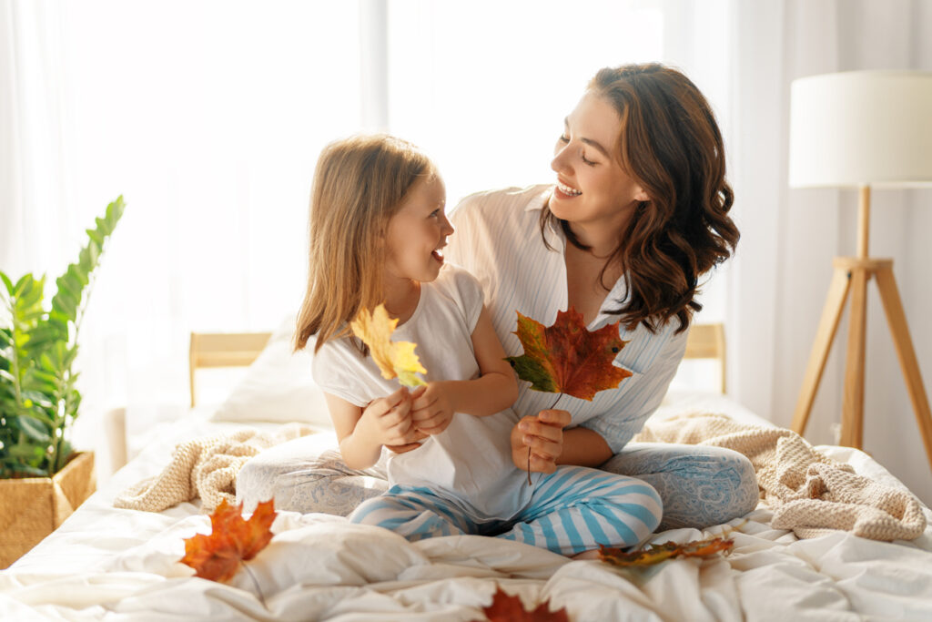 mom and daughter at home with fall leaves