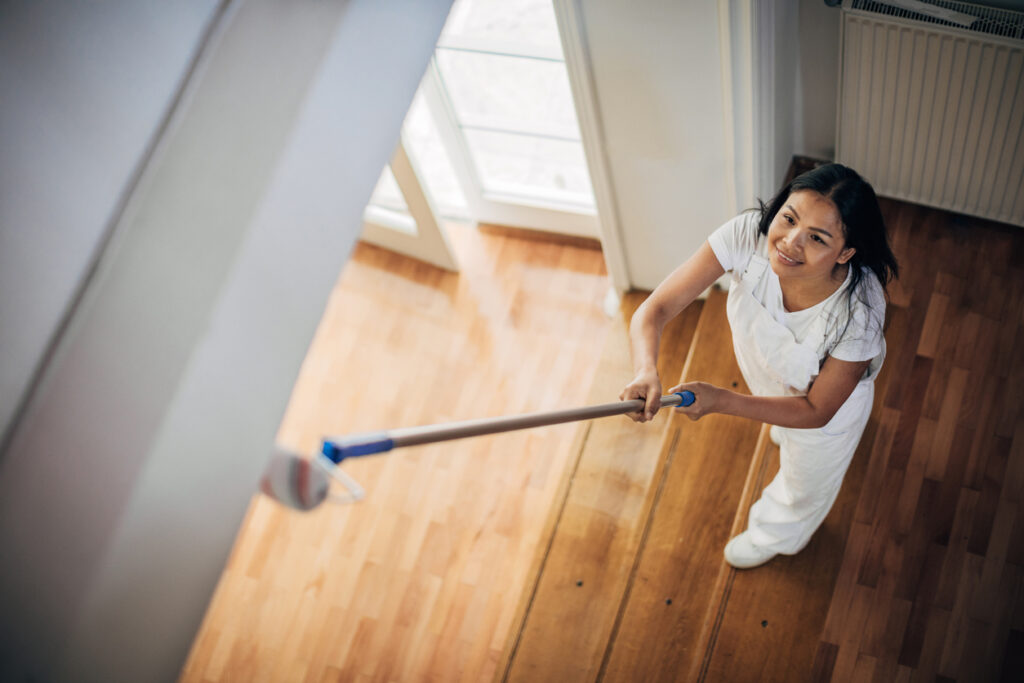 woman painting ceiling at home