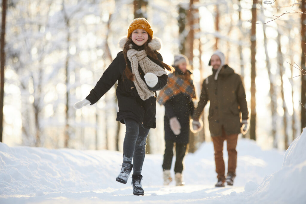 family hiking in wooded area in winter