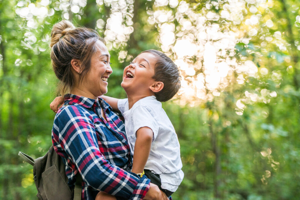 a young mother and son together in the woods