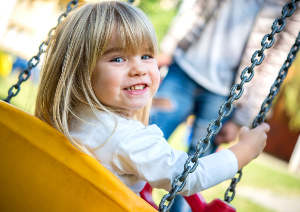 happy girl on playground swing