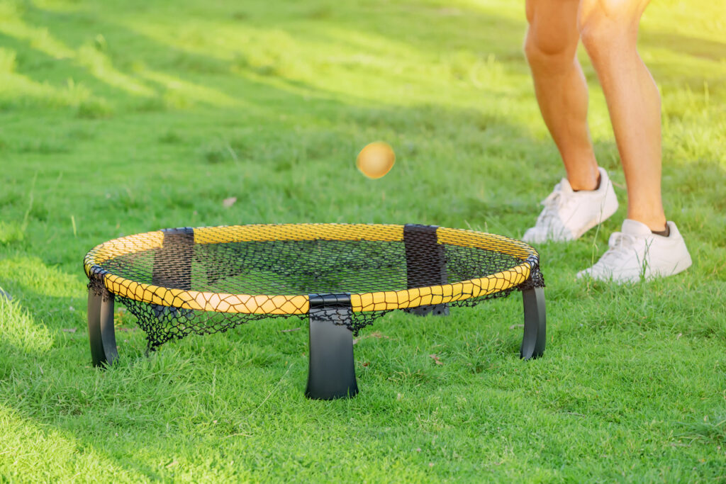 Playing spikeball outdoors on the grass