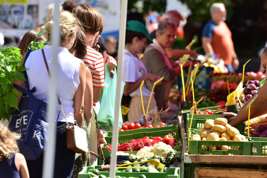 people shopping at an outdoor farmers market
