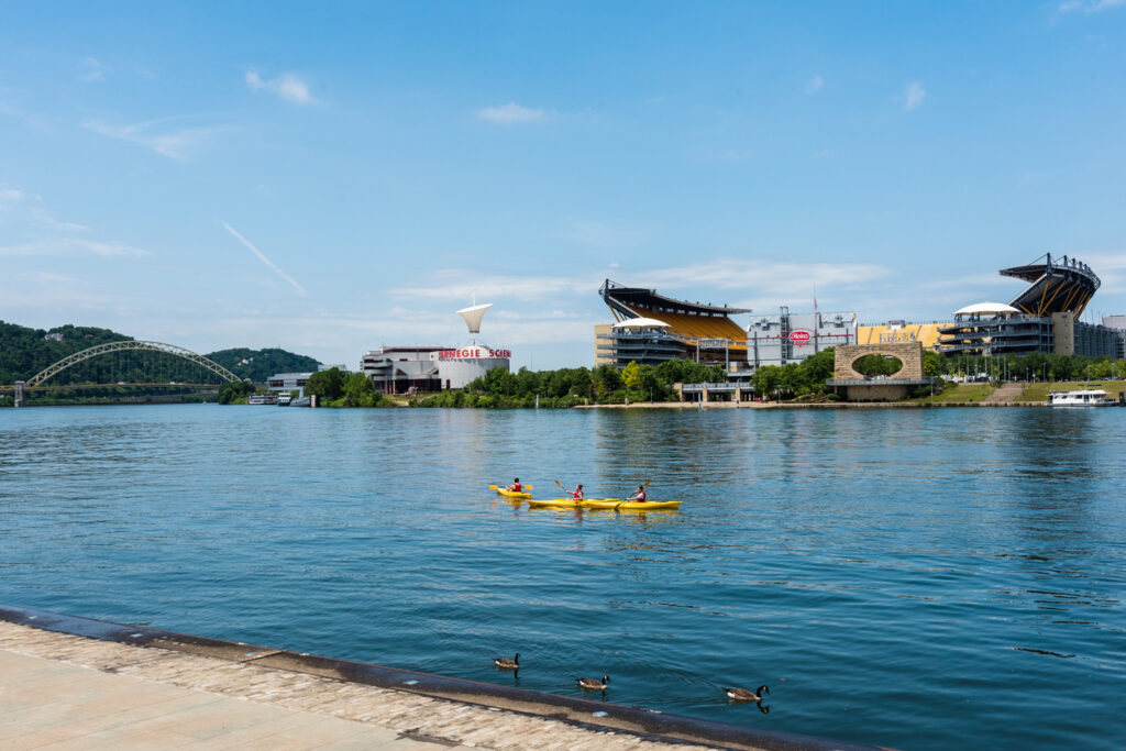  Three people kayaking in the Allegheny River in front of Heinz Field