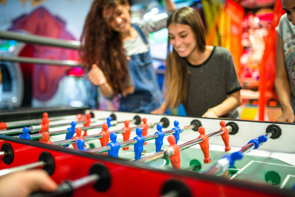 friends playing foosball at the arcade