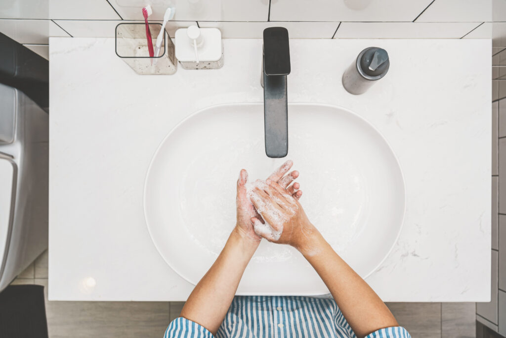 woman washing hands at bathroom sink