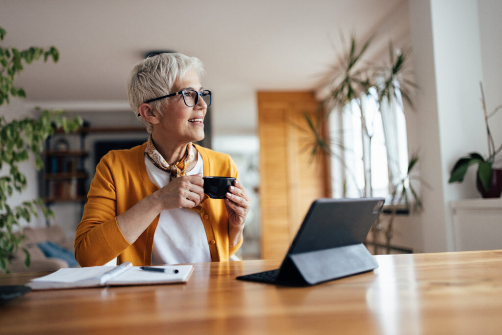 Happy mature woman, enjoying her coffee, while resting from work.