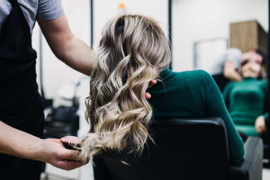 woman getting hair cut and colored at a salon