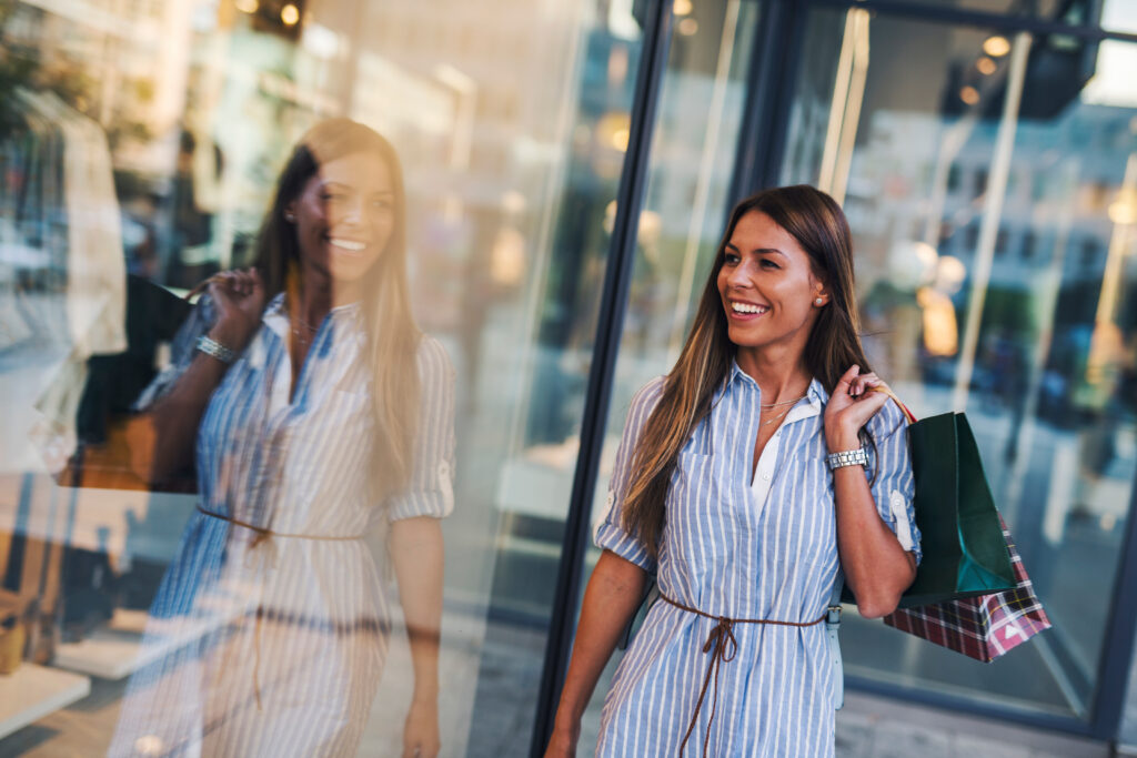 woman holding shopping bags window shopping