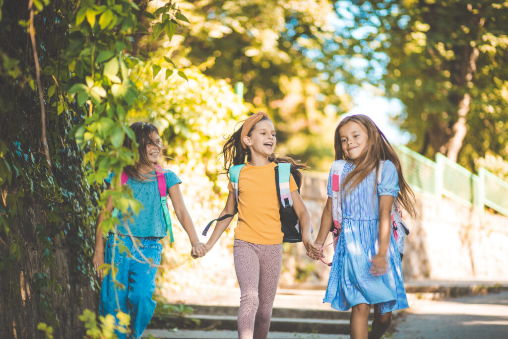 three elementary aged girls walking to school