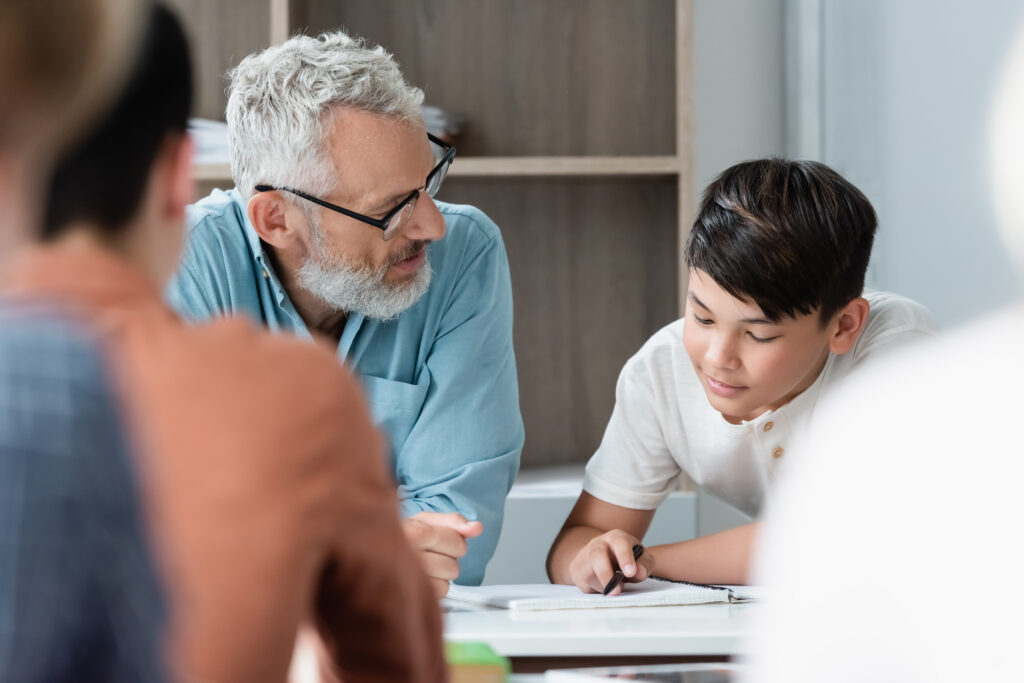 male teacher helping middle school boy with schoolwork