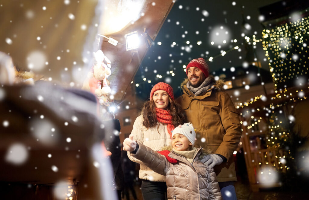 family enjoying a winter craft market outside at night