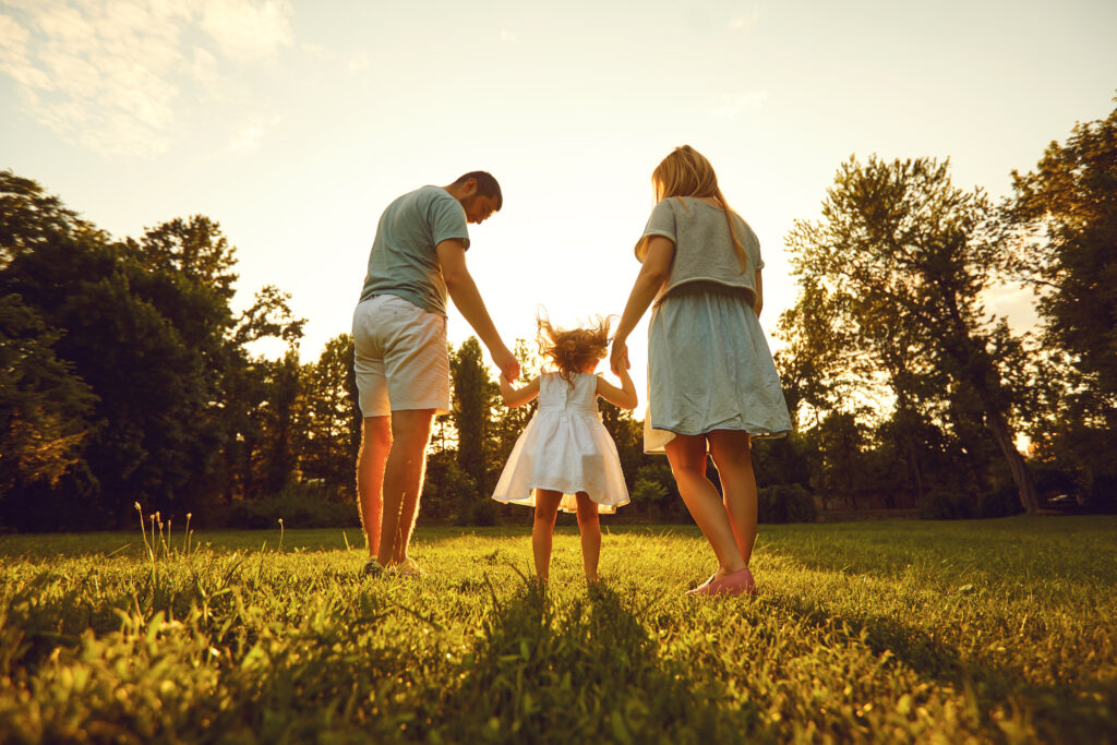 Happy family with children in the park at sunset. 